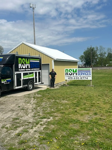 RSM Services owner standing outside HVAC and plumbing truck at Bryan storefront