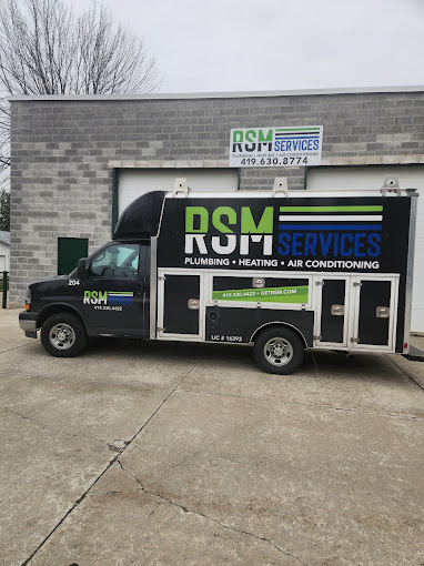 RSM Services owner standing outside HVAC and plumbing truck at Bryan storefront